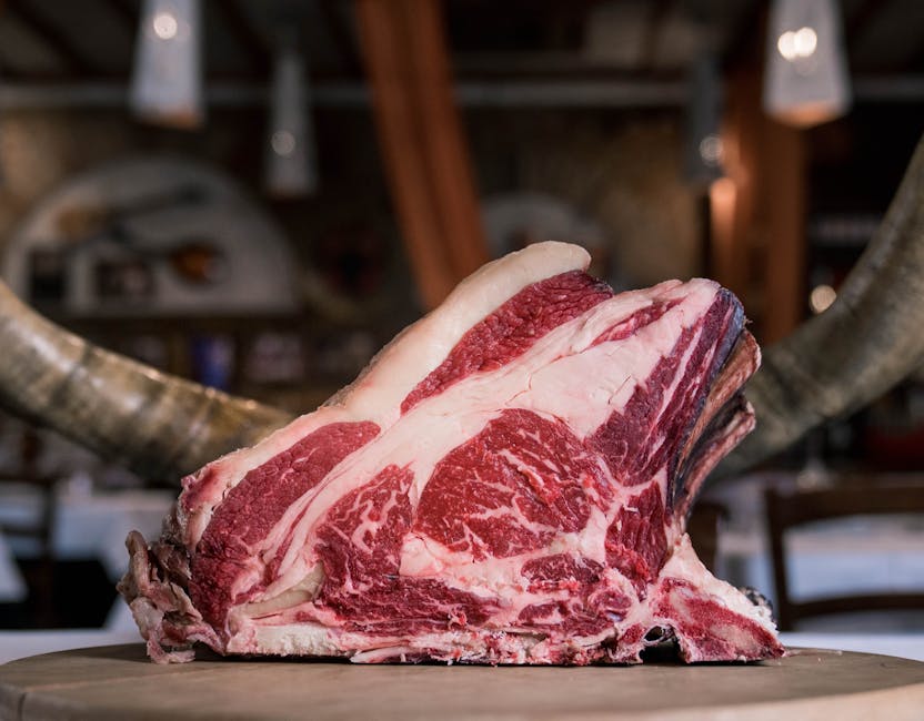 Morceau de bœuf bien persillé présenté sur une table en bois rustique, mettant en valeur sa texture crue et ses couleurs riches.